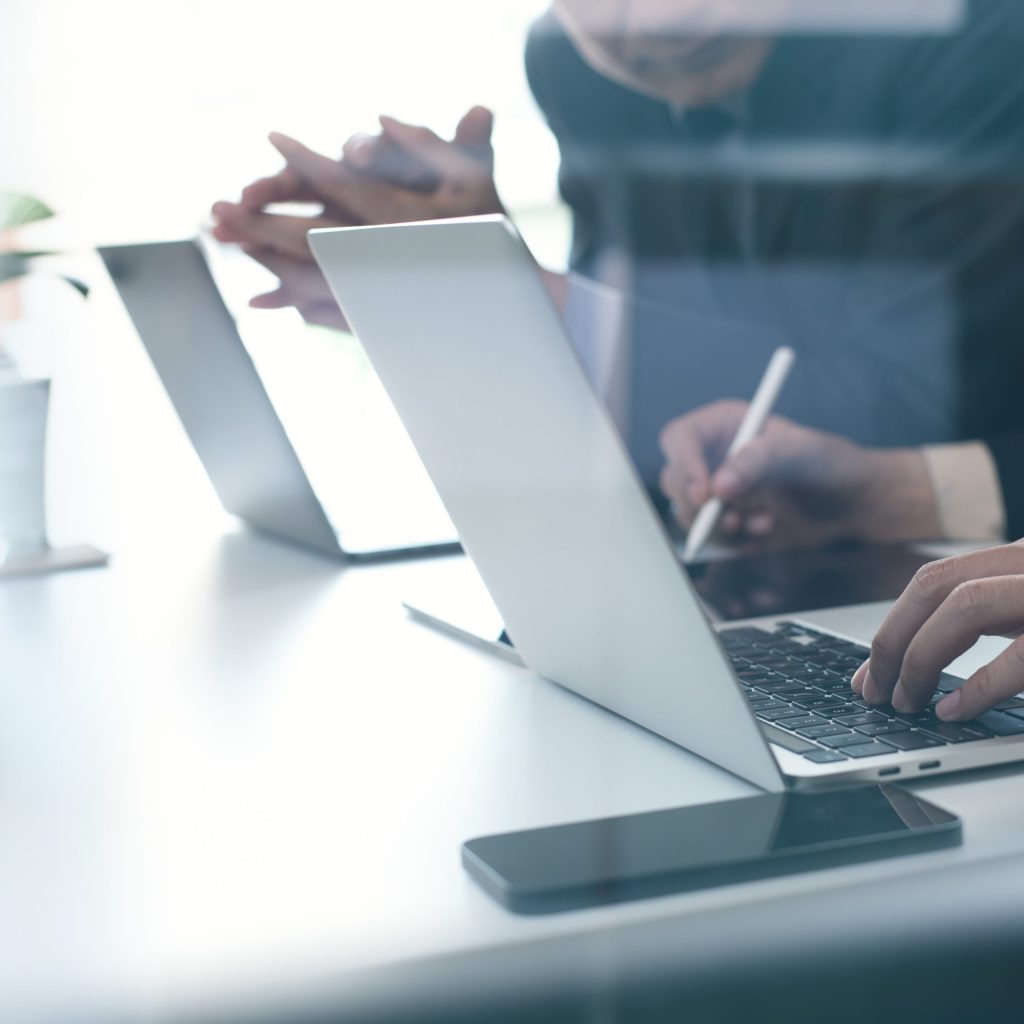 two businessmen discussing, working on a laptop computer remotely