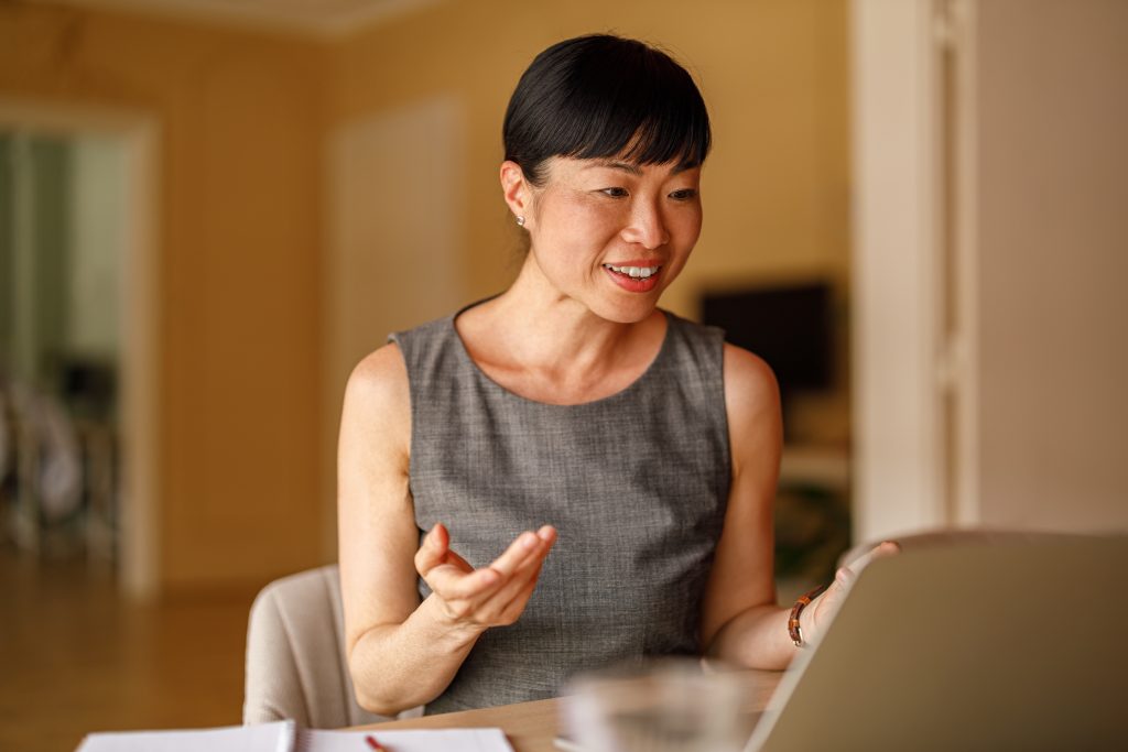 an Asian businesswoman attending a virtual meeting in her office space