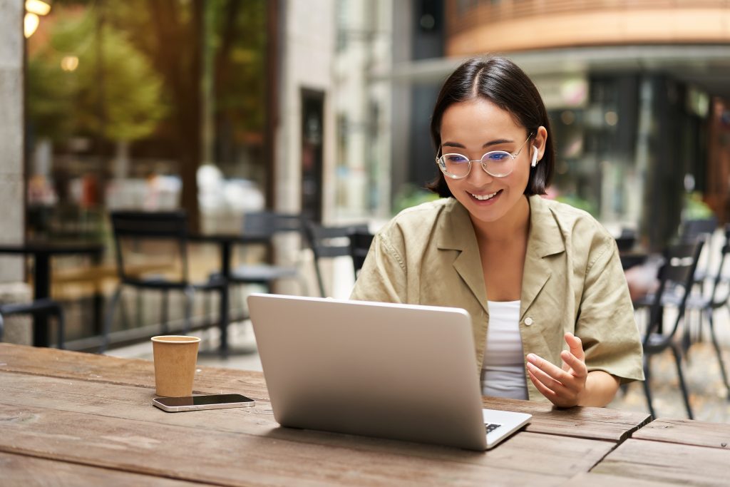 A lady in a coffee shop working remotely, thanks to a virtual business address in Singapore