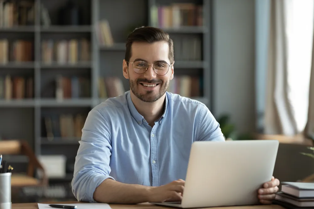professional office employee sitting at a desk while using his laptop