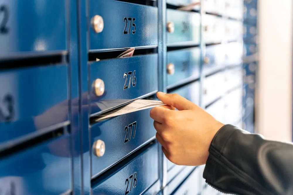 a man putting a letter in a PO Box