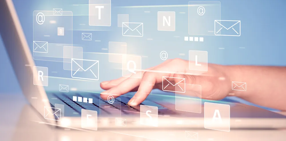 a hand typing on keyboard with messaging symbols signifying mail forwarding solutions of office address rentals